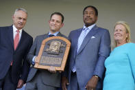 Hall of Fame baseball player Dave Winfield, second from right, stands next to inductee Bud Fowler's plaque held by Josh Rawitch, second from left, president of the National Baseball Hall of Fame and Museum, along with Rob Manfred, left, commissioner of Major League Baseball, and Jane Forbes Clark, right, chairman of the Board of Directors of The National Baseball Hall of Fame and Museum, during the Hall of Fame induction ceremony, Sunday, July 24, 2022, at the Clark Sports Center in Cooperstown, N.Y. (AP Photo/John Minchillo)
