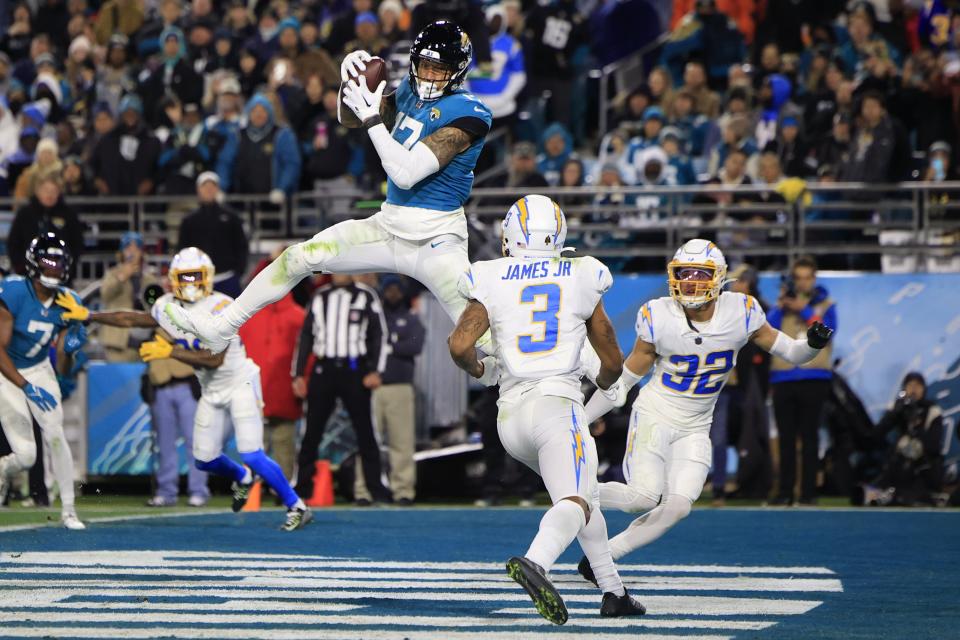 Jacksonville Jaguars tight end Evan Engram (17) scores a touchdown as Los Angeles Chargers safety Derwin James Jr. (3) and safety Alohi Gilman (32) look on and during the second quarter of an NFL first round playoff football matchup Saturday, Jan. 14, 2023 at TIAA Bank Field in Jacksonville, Fla. [Corey Perrine/Florida Times-Union]