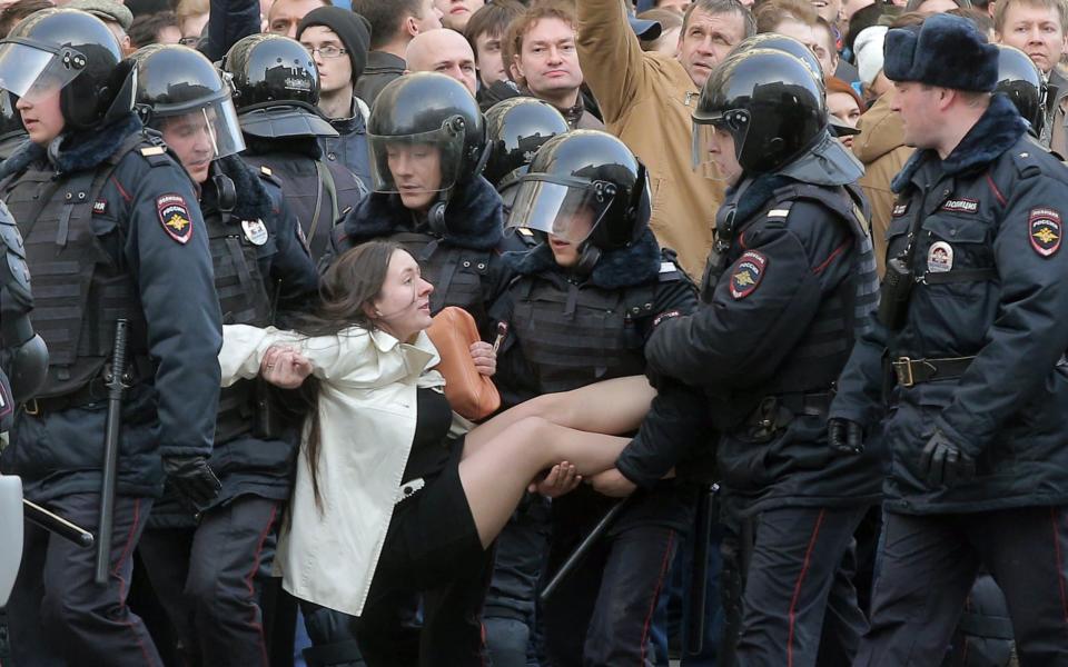 Russian riot policemen detain a demonstrator during an opposition rally in central Moscow, Russia - Credit:  MAXIM SHIPENKOV/EPA