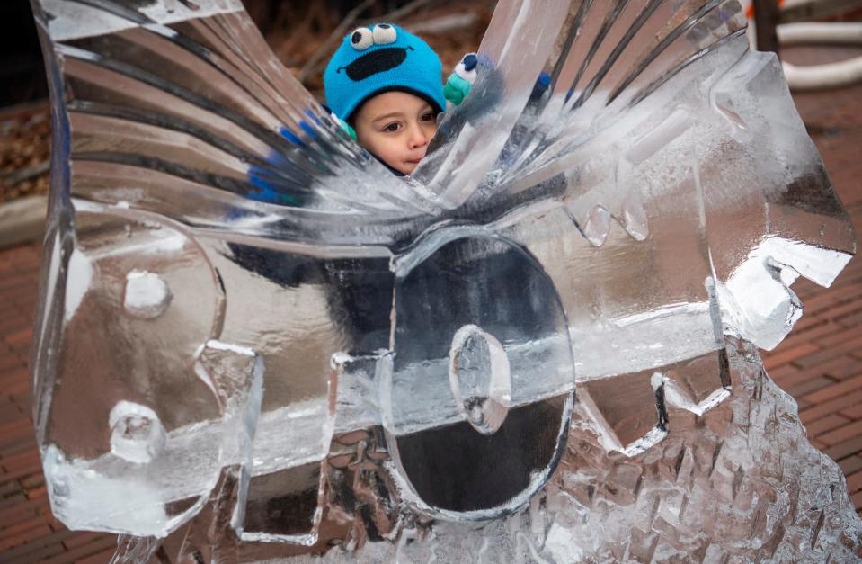 Beckett Dhanawade plays with an ice sculpture outside of The Mill during Freezefest on Friday, Jan. 20, 2023.