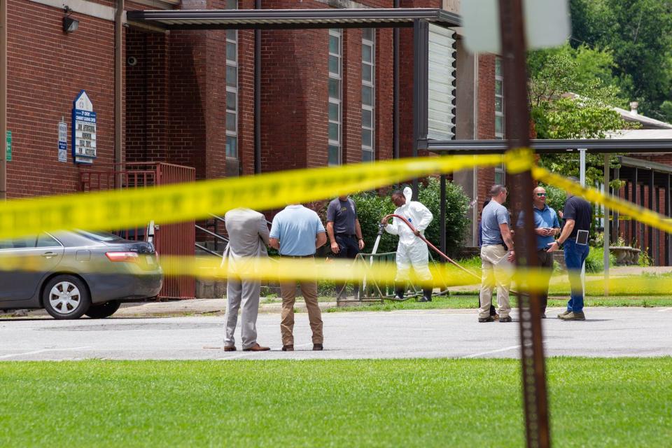 Officials, including Gadsden City Schools Superintendent Tony Reddick, watch as the scene outside Walnut Park Elementary School is cleaned on Thursday, June 9, 2022, following an incident in which an intruder attempted to enter the school.