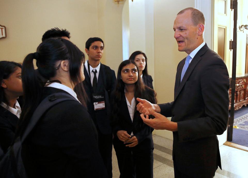 Assemblyman Kevin McCarty, D-Sacramento, right, talks with a group of high school students after his news conference concerning a proposed package of bills dealing with the recent college admissions scandal, Thursday, March 28, 2019, in Sacramento, Calif.
