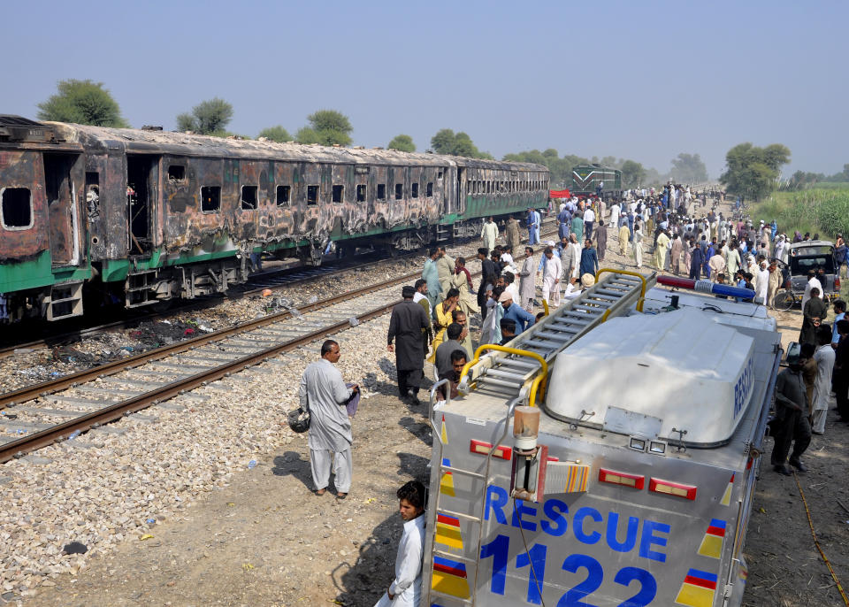 Pakistani soldiers and officials examine a train damaged by a fire in Liaquatpur, Pakistan, Thursday, Oct. 31, 2019. A massive fire engulfed three carriages of the train traveling in the country's eastern Punjab province (AP Photo/Siddique Baluch)