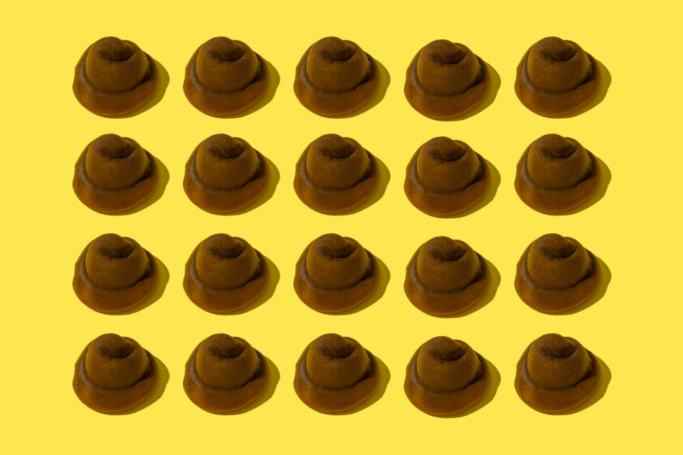 Multiple brown felt hats arranged in a grid pattern on a yellow background