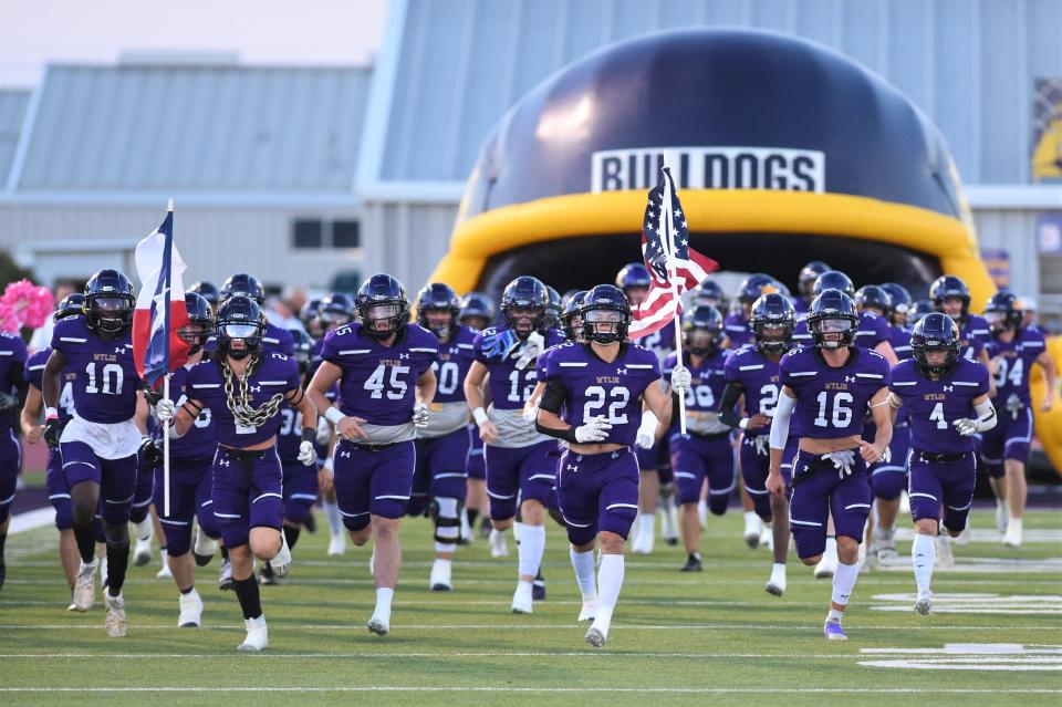 The Wylie football team takes the field before last season's game against Canyon Randall at Hugh Sandifer Stadium.