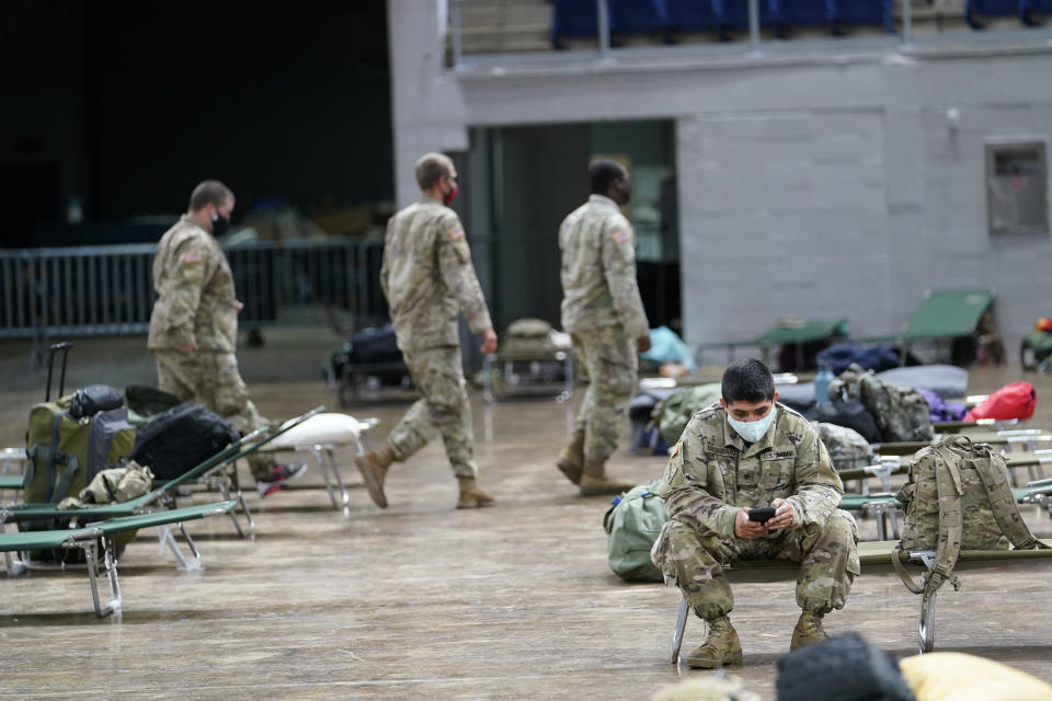 Members of the Louisiana National Guard prepare beds in a shelter ahead of Hurricane Delta, Friday, Oct. 9, 2020, in Lake Charles, La. Forecasters said Delta — the 25th named storm of an unprecedented Atlantic hurricane season — would likely crash ashore Friday evening somewhere on southwest Louisiana's coast. (AP Photo/Gerald Herbert)