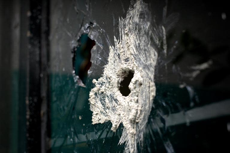 Bullet holes in the window of a house neighbouring the one where gunmen attacked the police in Ocotlan, Jalisco state