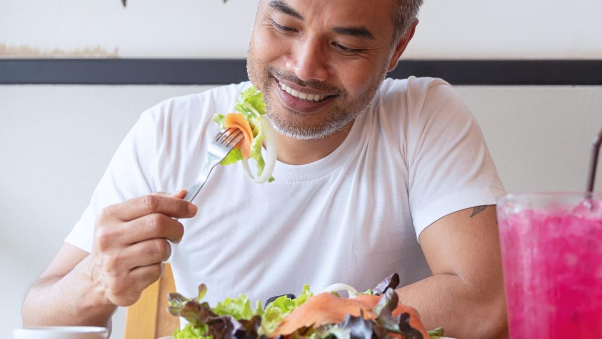 young happy man enjoying in a healthy meal