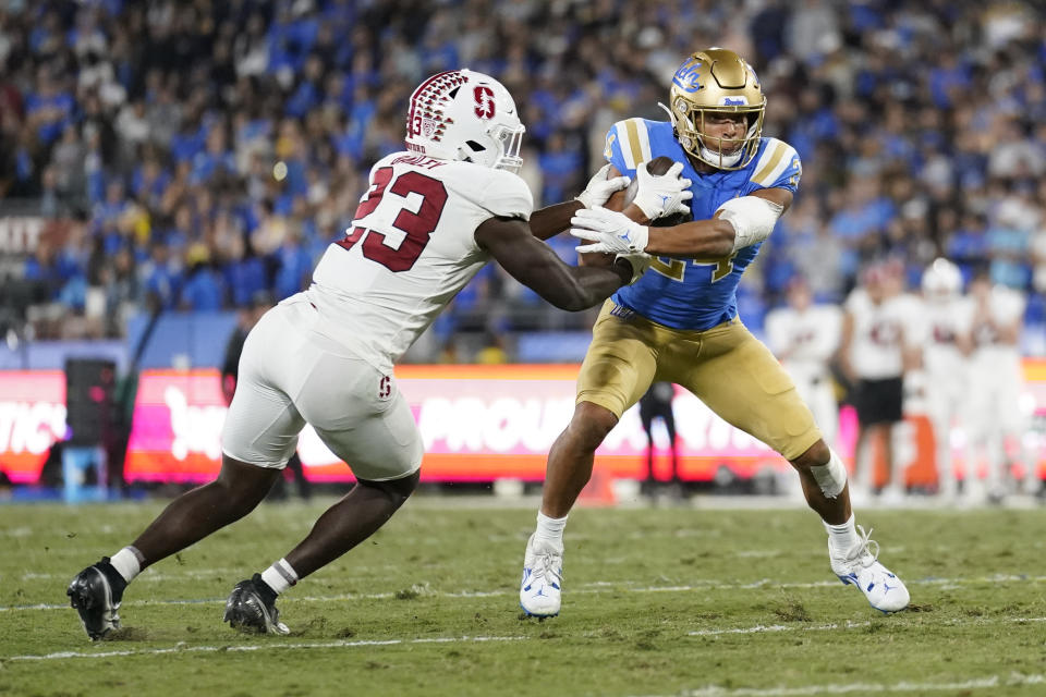 UCLA running back Zach Charbonnet (24) is tackled by Stanford defensive end David Bailey (23) during the first half of an NCAA college football game in Pasadena, Calif., Saturday, Oct. 29, 2022. (AP Photo/Ashley Landis)