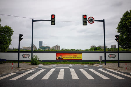 A poster with a portrait of Chinese President Xi Jinping overlooks a street in Shanghai, China, August 30, 2017. The slogan reads: "The Four Comprehensives: Comprehensively build a moderately prosperous society. Comprehensively deepen reform. Comprehensively govern the nation according to law. Comprehensively strictly govern the Party." Picture taken August 30, 2017. REUTERS/Aly Song