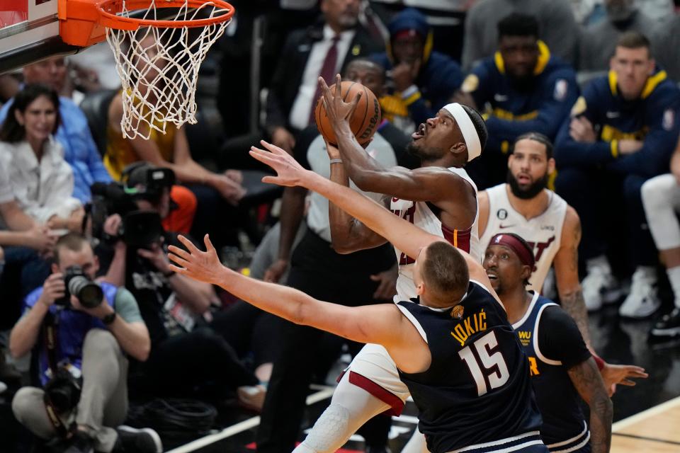 Miami Heat forward Jimmy Butler (22) drives to the basket as Denver Nuggets center Nikola Jokic (15) during the second half of Game 4 of the basketball NBA Finals, Friday, June 9, 2023, in Miami.