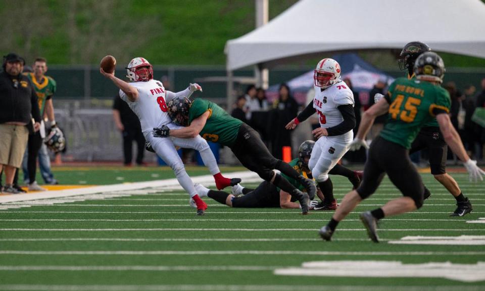 Law Hogs linebacker Travis Stanfield hits Fire Dogs quarterback Cameron Barrios as he releases the ball, forcing a forth quarter interception by defensive end Tim Merrill in the 50th Pig Bowl on Saturday at Hughes Stadium. Nathaniel Levine/nlevine@sacbee.com