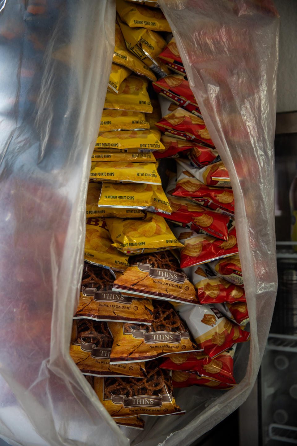 Bags of chips and pretzels are enclosed in a plastic bag near the fridge at Abul Kalam Azad's newsstand near New York Criminal Court on April 4, 2023. (Julius Constantine Motal / NBC News)