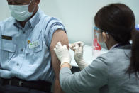 A Tokyo Metropolitan Government employee takes the Moderna's COVID-19 vaccine shot at a newly opened vaccination center at the local government building, Thursday, July 1, 2021, in Tokyo. The pressure of hosting an Olympics during a still-active pandemic is beginning to show in Japan. While Japan has made remarkable progress to vaccinate its population against COVID-19, the drive is losing steam because of supply shortages.(AP Photo/Eugene Hoshiko)