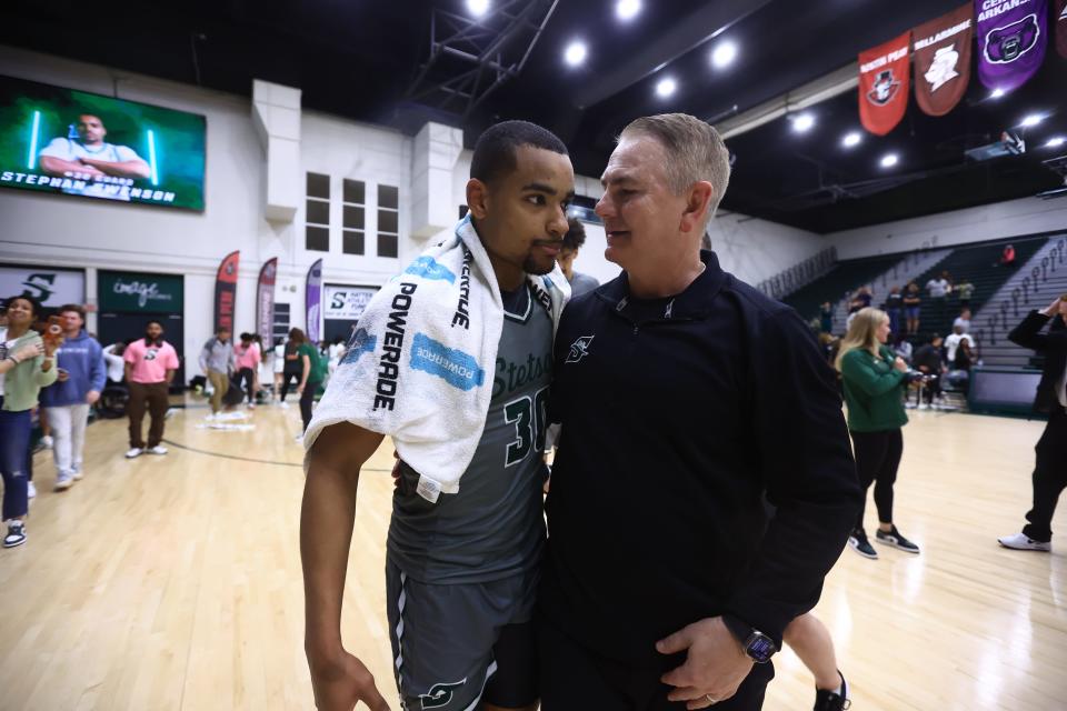 Stetson coach Donnie Jones (right) shares a moment with point guard Stephan Swenson (30) after the Hatters earned an 88-87 win over Jacksonville in an ASUN semifinal in DeLand on Thursday, March 7, 2024.