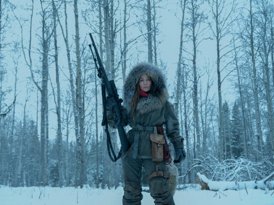 jennifer lopez holding a machine gun in a snowy forest in a scene from the mother