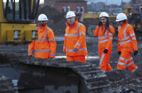 Britain's Prime Minister Boris Johnson, 2nd left, walks with apprentices during a tour of the Curzon Street railway station, where the new High Speed 2 (HS2) rail project is under construction, in Birmingham, England, Tuesday Feb. 11, 2020. Boris Johnson said his Cabinet had given the “green light” to the high-speed rail line that will link London with central and northern England, despite the huge cost prediction and opposition from environmentalists. (Eddie Keogh/Pool via AP)