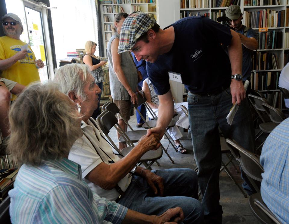 A fan shakes author Larry McMurtry's hand at an auction of some of McMurtry's rare books  in Archer City in 2012.