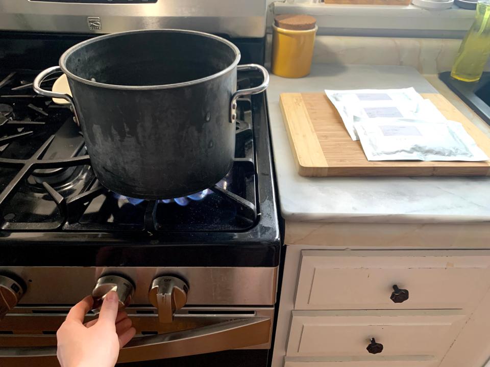 pot of water on stove next to foil packets of astronaut food on countertop