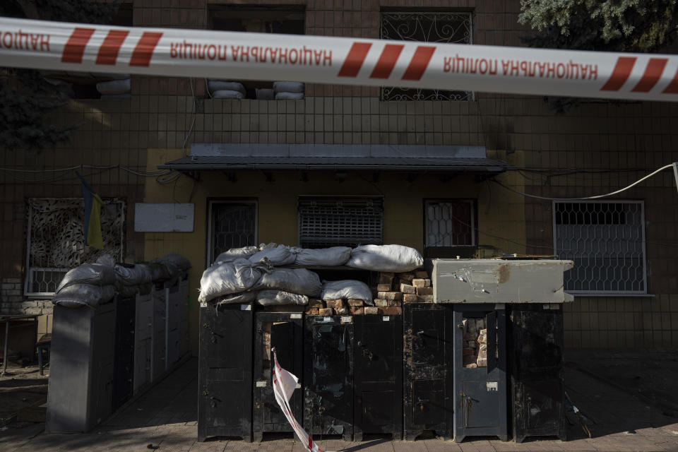 Tape cordons off a police department building in Izium, Ukraine, Thursday, Sept. 22, 2022. Ukrainian civilians said they were held and tortured at the site by Russian soldiers. (AP Photo/Evgeniy Maloletka)