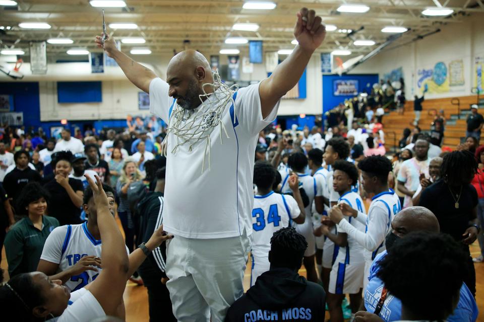 Ribault head coach Charles Showers celebrates the Trojans' district championship against Bishop Kenny.