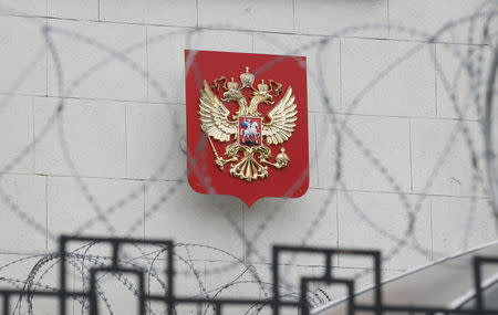 FILE PHOTO: A coat of arms is seen through barbed wire on the wall of the Russian embassy in Kiev, Ukraine March 26, 2018. REUTERS/Gleb Garanich/File Photo