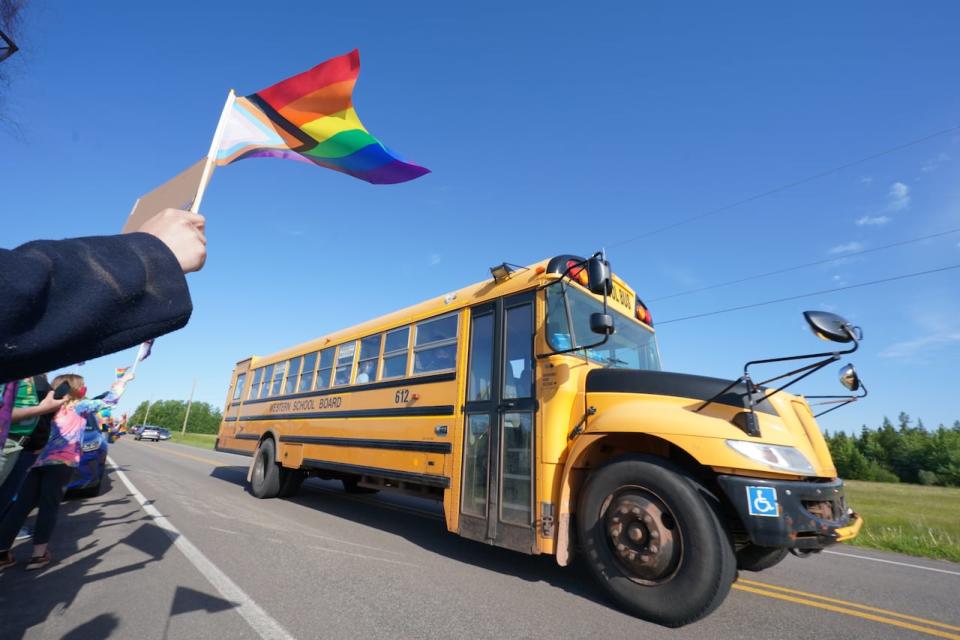 LGBTQ supporters wave their flags to show support for students going to school at East Wiltshire School in Cornwall, Prince Edward Island on Monday June 14, 2021. School board officials in P.E.I. are investigating reports that a recent Pride Day event at a junior high school was disrupted by some students who dressed in black and harassed classmates who said they supported the LGBTQ community. 