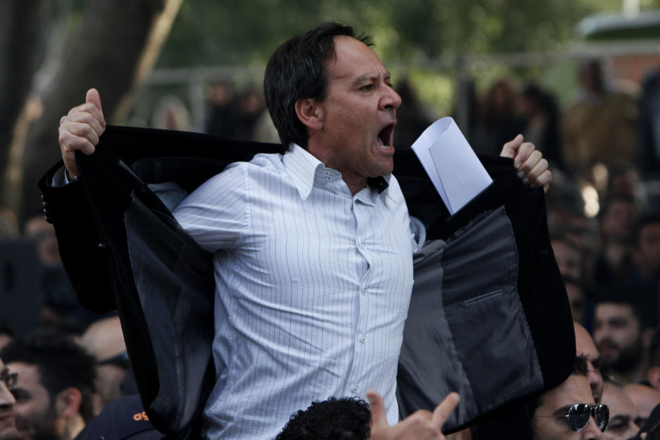 A protestor shouts at riots police outside of the Parliament during a strike to protest government plans to privatize the state-run organizations in the capital Nicosia, Cyprus, Thursday, Feb. 27, 2014. Hundreds of protesters have gathered outside Cyprus' parliament to voice opposition against legislation that will pave the way for the privatization of state-owned companies. (AP Photo/Petros Karadjias)