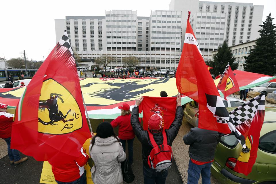 Ferrari fans from France, Italy and Germany attend a silent 45th birthday tribute to seven-times former Formula One world champion Michael Schumacher in front of the CHU hospital emergency unit in Grenoble