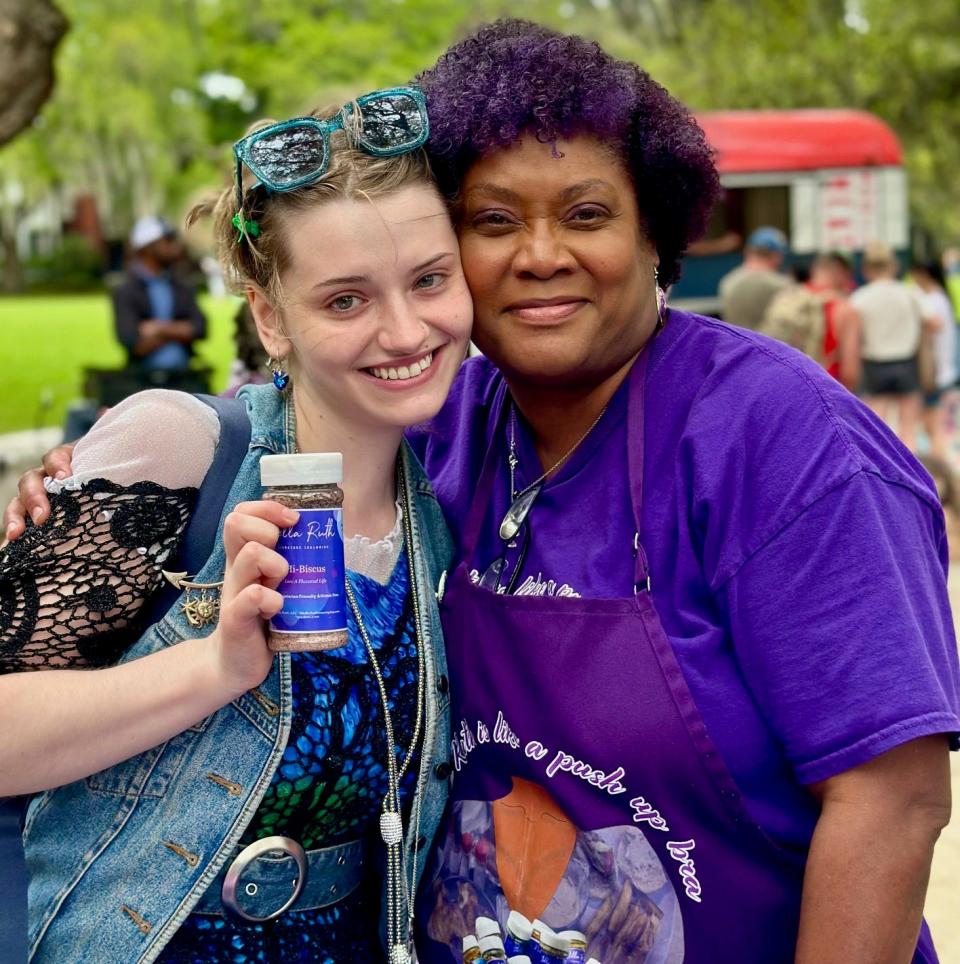 Kimberly Brown (right), owner of Stella Ruth's Signature Seasonings, hugs a happy customer holding a shaker of custom herbs and spices.