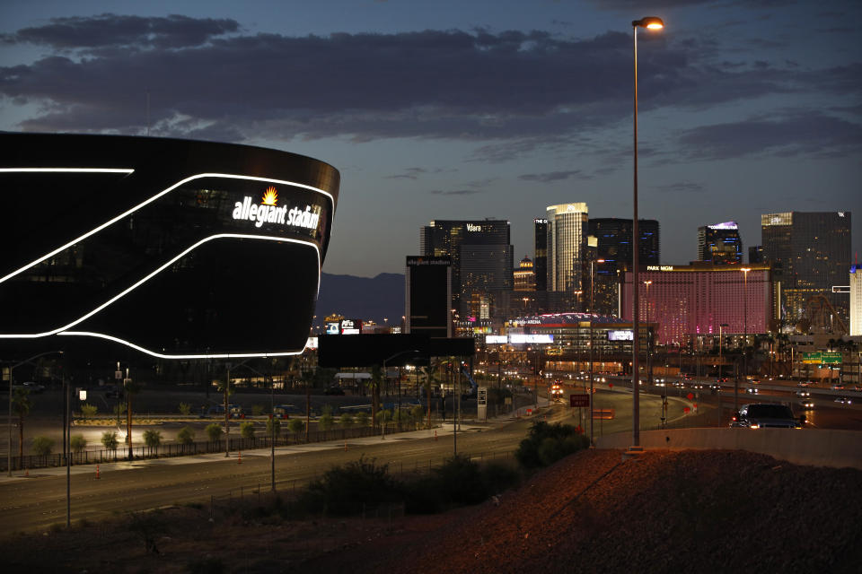 An exterior view of the new Allegiant Stadium with the Las Vegas Strip in the background.