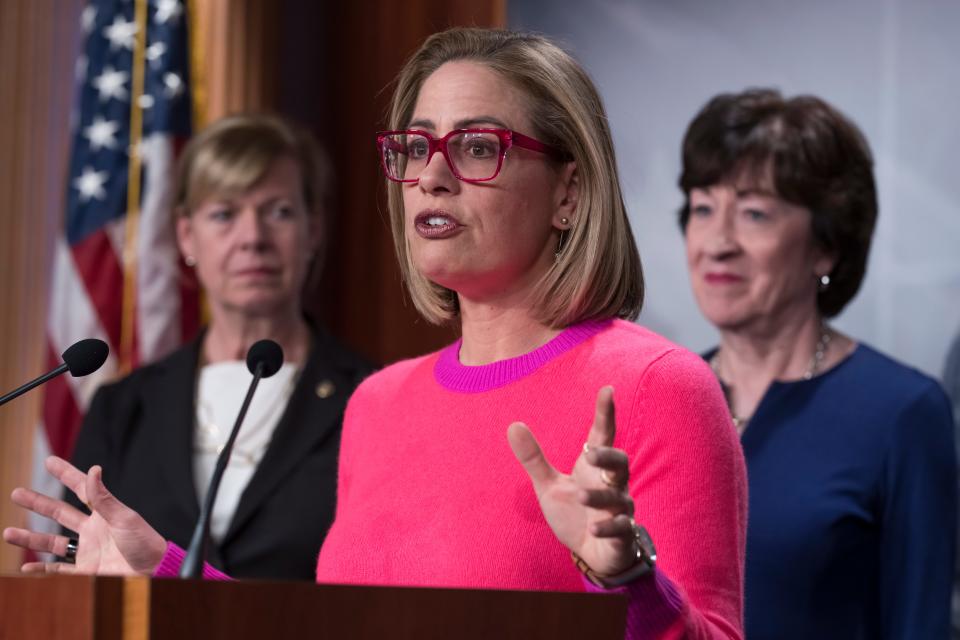 Sen. Kyrsten Sinema, D-Ariz., flanked by Sen. Tammy Baldwin, D-Wis., left, and Sen. Susan Collins, R-Maine, speaks to reporters following Senate passage of the Respect for Marriage Act, at the Capitol in Washington, Tuesday, Nov. 29, 2022.