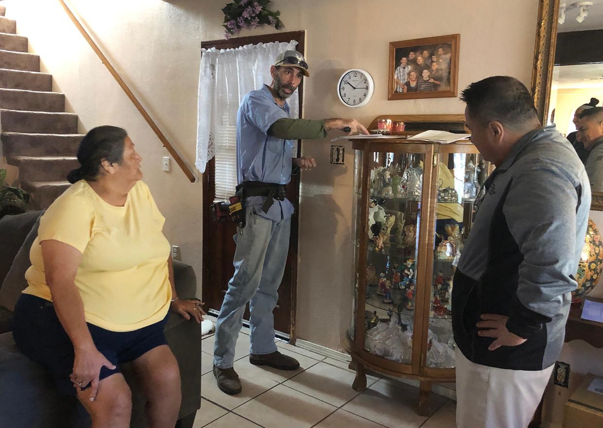 Lighting Inc. General Manager Gabriel Trinidad, right, and electrician Jason Chedester inspect Debbie Hernandez's home Wednesday. Lighting Inc. is donating electrical services for the Hernandez family as part of Season for Caring.