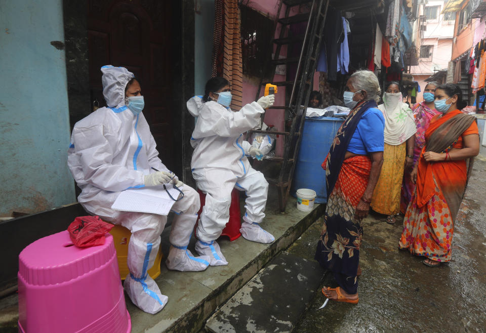 Health workers screen people for COVID-19 symptoms in Dharavi, one of Asia's biggest slums, in Mumbai, India, Tuesday, Aug. 11, 2020. India has the third-highest coronavirus caseload in the world after the United States and Brazil. (AP Photo/Rafiq Maqbool)