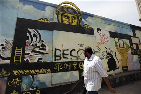 A man walks past a graffiti in Cairo May 21, 2014. REUTERS/Amr Abdallah Dalsh