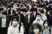 A station passageway is crowded with commuters wearing face mask during a rush hour Tuesday, May 26, 2020, in Tokyo. Japanese Prime Minister Shinzo Abe lifted a coronavirus state of emergency in Tokyo and four other remaining prefectures on Monday, May 25, ending the declaration that began nearly eight weeks ago.(AP Photo/Eugene Hoshiko)