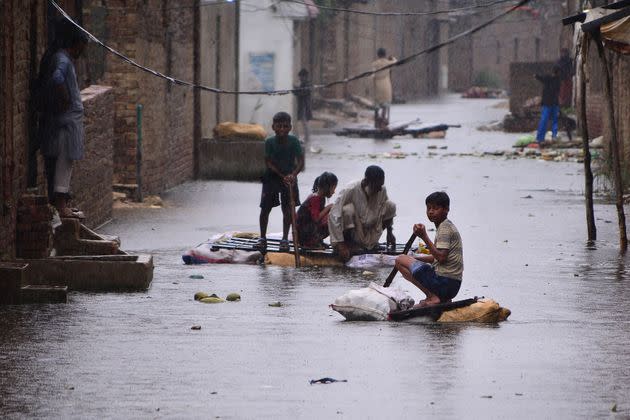 Residents use rafts to make their way along a waterlogged street in a residential area after a heavy monsoon rainfall in Hyderabad on August 24, 2022. Record monsoon rains were causing a 