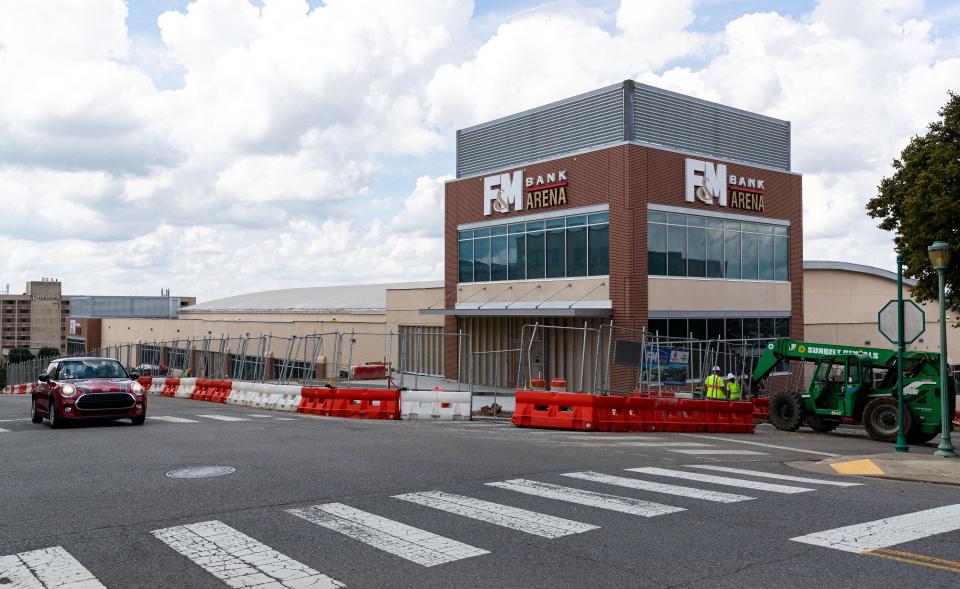 Workers move barricades to open up a street during construction of the F&M Bank Arena in downtown Clarksville, Tenn., on Sep. 9, 2022. 