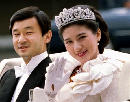 FILE PHOTO: Crown Princess Masako waves to Imperial Household staff alongside Crown Prince Naruhito as they depart for their wedding parade to Togu Palace from the Imperial Palace in Tokyo