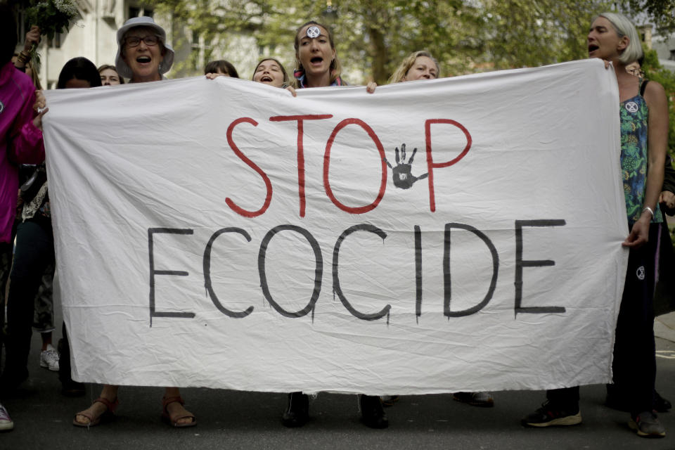 Extinction Rebellion climate change protesters hold a banner as they briefly block traffic going around Parliament Square in central London, Wednesday, April 24, 2019. The non-violent protest group, Extinction Rebellion, is seeking negotiations with the government on its demand to make slowing climate change a top priority. (AP Photo/Matt Dunham)