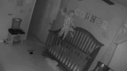 The baby balances on the side of his crib, in a scene that looks like a clip from Paranormal Activity. Photo: YouTube