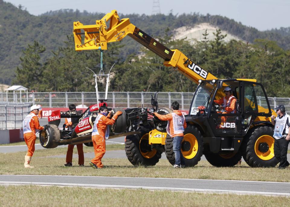 Workers remove the car of Lotus Formula One driver Kimi Raikkonen of Finland after it crashed during the first practice session of the Korean F1 Grand Prix at the Korea International Circuit in Yeongam October 4, 2013. REUTERS/Lee Jae-Won (SOUTH KOREA - Tags: SPORT MOTORSPORT F1)