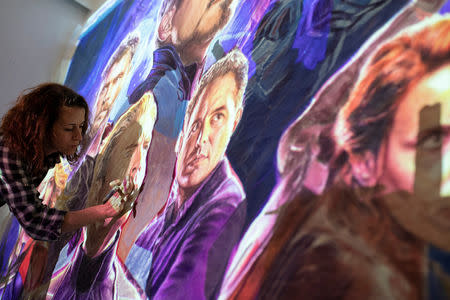 Greek artist Virginia Axioti works on the billboard of the "Avengers: Endgame" movie in Athens, Greece, April 21, 2019. Picture taken April 21, 2019. REUTERS/Alkis Konstantinidis