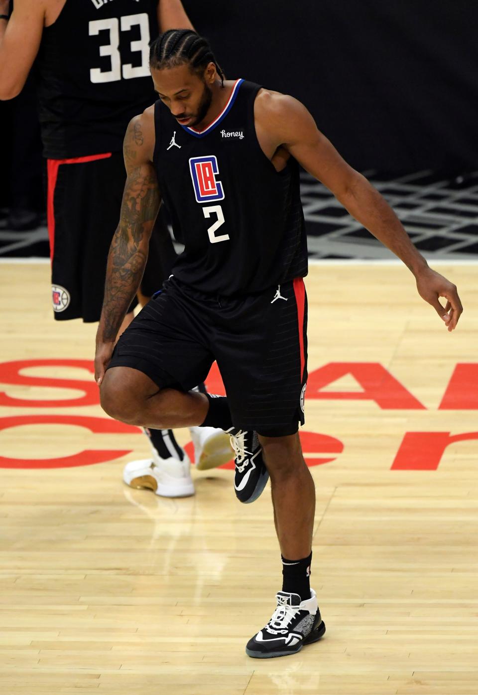 Kawhi Leonard holds his knee during the second half of the Clippers' Game 4 win over the Jazz.