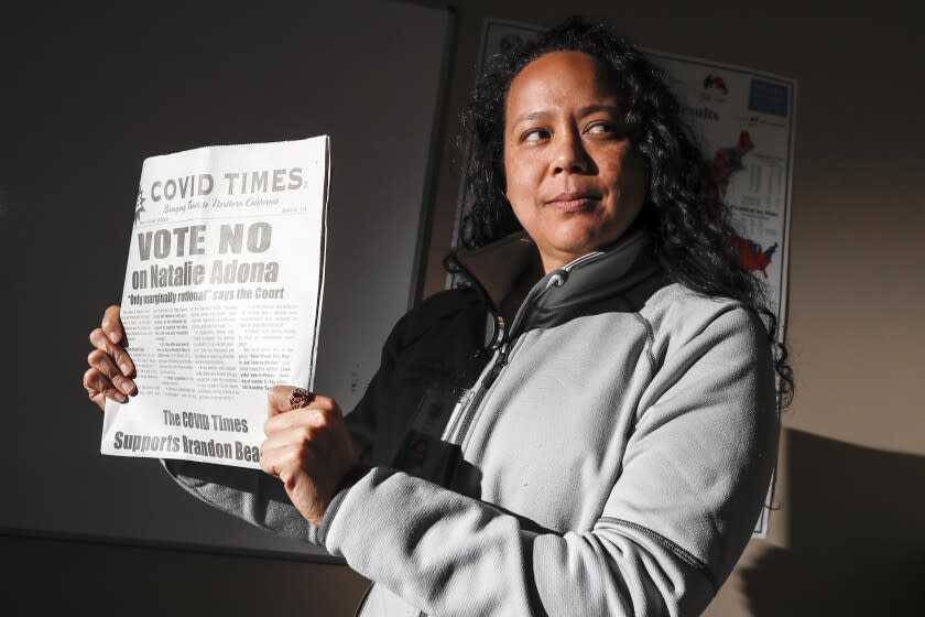 Nevada City, CA, Monday, June 6, 2022 - Assistant County Clerk, Recorder of Nevada County Natalie Adona is running for County Clerk and has been targeted with apparently racist attack ads from her opponent Paul Gilbert, a self-titled election auditor who is concerned the voting system is susceptible to cheating. She holds up a new copy of the Covid times that emphatically tells readers to vote against her. (Robert Gauthier/Los Angeles Times)