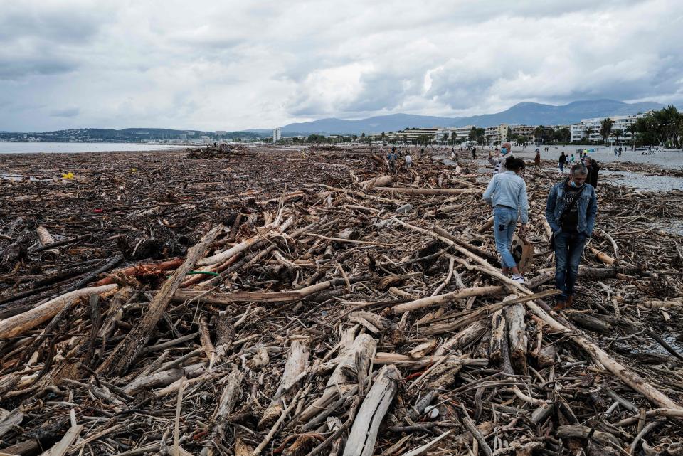 People walk on tree branches after Storm Alex in Saint-Laurent-du-Var, southern France.