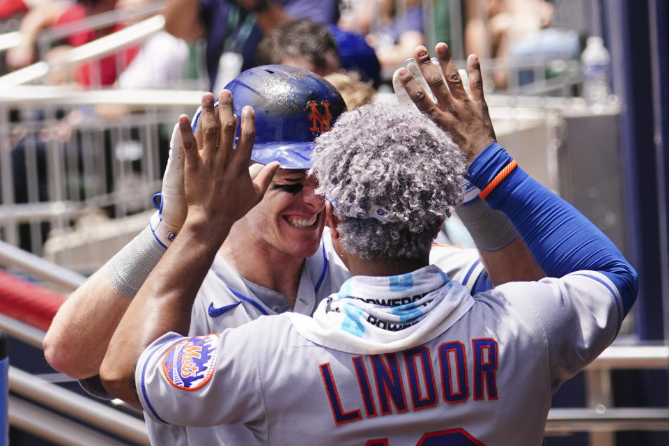 New York Mets' Mark Canha (19) celebrates with Francisco Lindor (12) after hitting a home run in the sixth inning of a baseball game against the Atlanta Braves Wednesday, July 13, 2022, in Atlanta. (AP Photo/John Bazemore)
