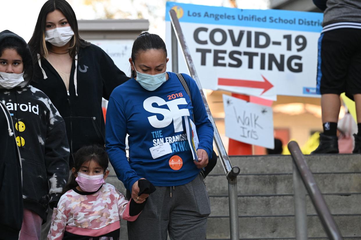 A family leaves a COVID-19 testing and vaccination site in Los Angeles.