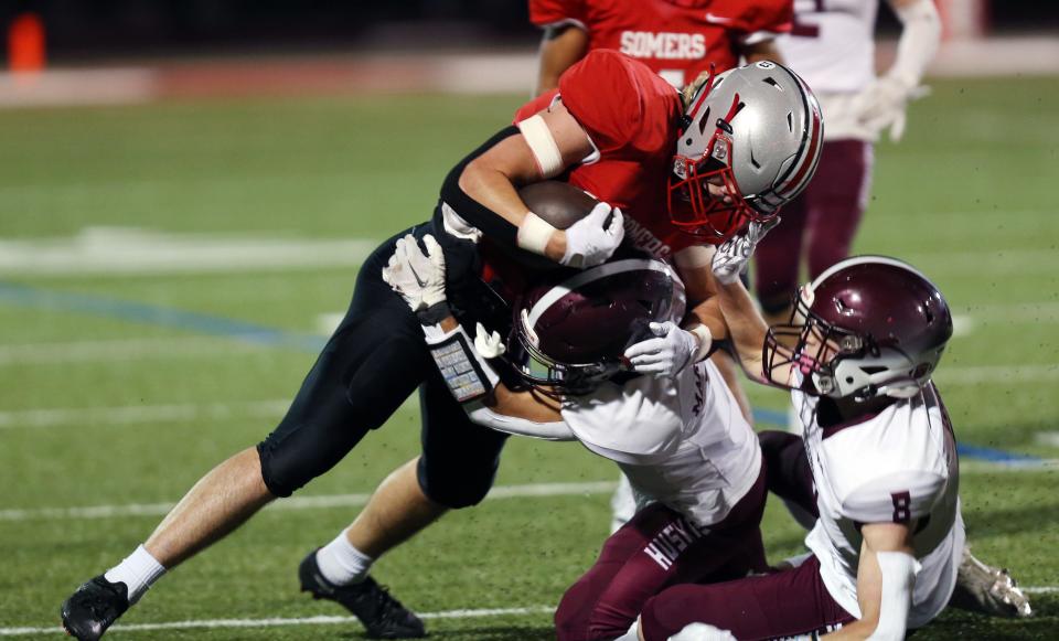 Somers' Luke Savino (7) looks for some running room in the Harrison defense during playoff football action at Somers High School Nov. 4, 2022. 