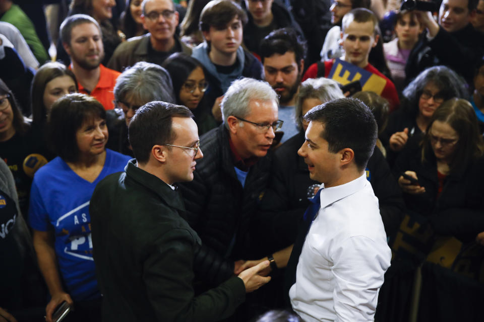 Democratic presidential candidate former South Bend, Ind., Mayor Pete Buttigieg, right, looks to his husband Chasten Buttigieg, left, as they meets members of the audience during a campaign event at Northwest Junior High, Sunday, Feb. 2, 2020, in Coralville, Iowa. (AP Photo/Matt Rourke)